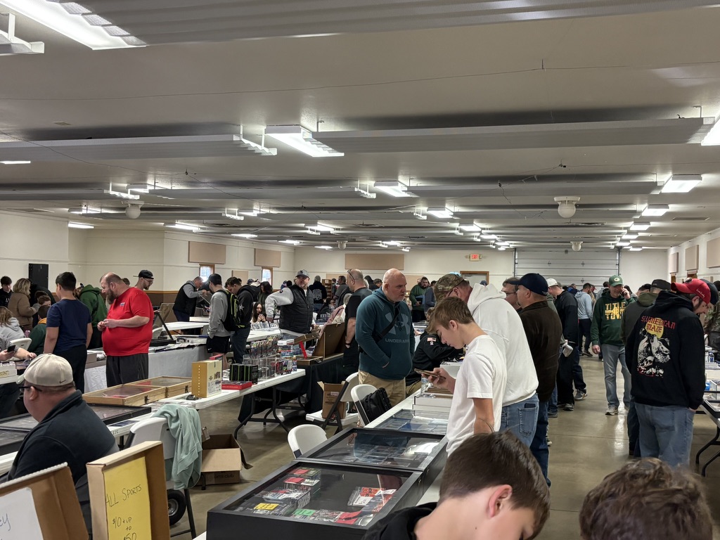 A lively aisle of sports card vendors and shoppers